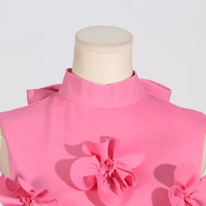 Detailed macro view of 3D fabric flower appliqués and stand collar on pink sleeveless dress