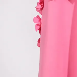 Macro view of 3D floral applique on a vibrant pink sleeveless maxi dress.