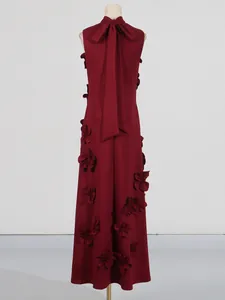 Elegant wine red sleeveless maxi dress featuring floral appliqué and a bow tie back
