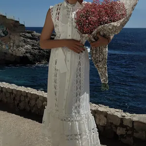 Gros plan d'une robe blanche élégante avec des détails de broderie en dentelle.