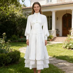 Detail view of elegant vintage white dress with lantern sleeves and tiered ruffles
