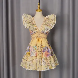 Detail view of a French-style floral mini dress with deep V-neck and ruffle sleeves.