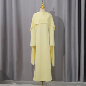 Detail view of a yellow high waist dress with elegant pearl-trimmed shawl on mannequin