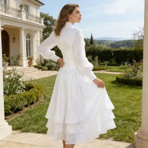Detail of an elegant vintage white tiered dress with lantern sleeves and a cinched waist.