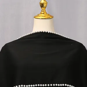 Makroansicht eleganter weißer Perlenverzierungen an einem vintage schwarzen Schal