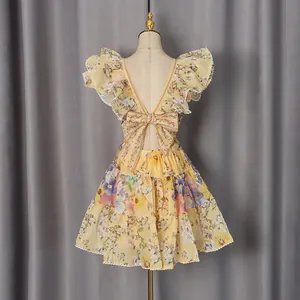 Back view of a French-style floral mini dress with ruffled sleeves and a bow detail.