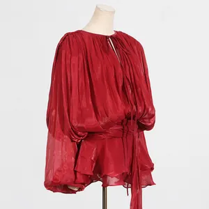 Detailed view of red long sleeve dress with ruffles and a metallic finish