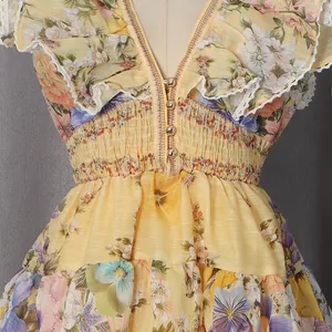 Detailed shot of yellow floral dress with deep V-neck buttons and ruffle trims.