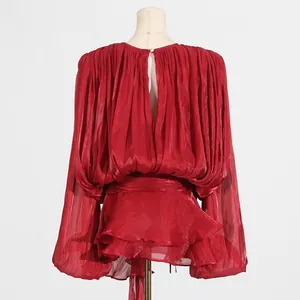 Back view of red pleated long-sleeve dress with ruffled hem and teardrop opening