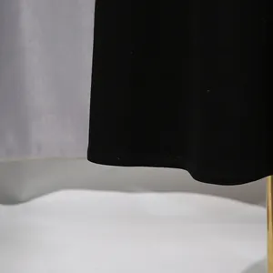 Detailansicht des eleganten, einfarbig schwarzen Kleidersaums mit hochwertigen Nähten.