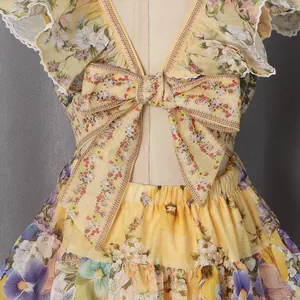 Back detail view of elegant yellow floral print dress with deep V-neck and bow