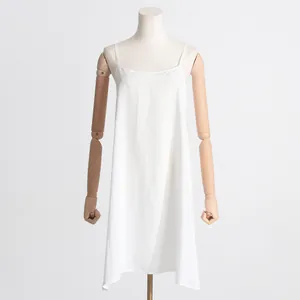 Robe à bretelles blanche minimaliste vue détaillée sur un mannequin en bois.