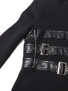 Gros plan d'une robe en maille noire avec des lanières en similicuir et des boucles en métal.