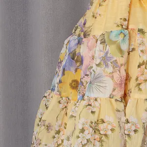 Detailed close-up shot of a yellow tiered dress featuring vintage floral patterns.