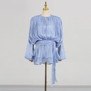 Detailed view of light blue pleated mini dress with shimmering fabric and waist tie.