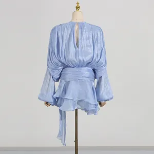 Back view detail of light blue shimmery ruffled dress with waist tie on mannequin