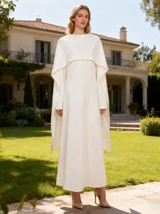 Elegantes weißes Kleid mit hoher Taille und Perlen-Schal in luxuriöser Gartenanlage