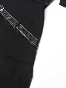 Détail en gros plan d'une robe noire avec ceinture en cuir et boucle métallique argenté.