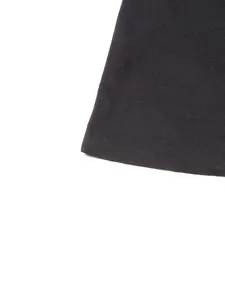 Détail en gros plan montrant la texture côtelée noire de cette élégante robe longue.