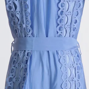 Détail d'une robe bleu clair montrant de la broderie fine et de la dentelle à jour