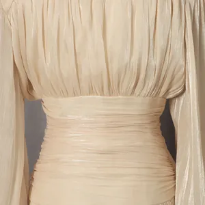 Close-up detail of champagne pleated fabric and slim waist of an elegant evening dress