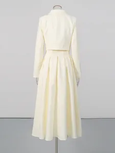 Elegant cream two-piece set with beaded cropped top and high-waist pleated skirt.