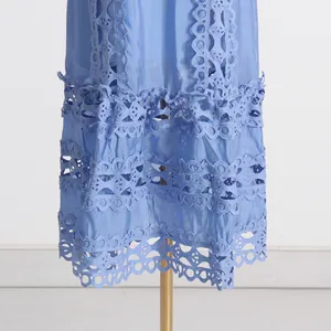 Gros plan sur les broderies ajourées et les détails en dentelle d'une robe bleue de style français