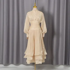 Elegant champagne French dress with lantern sleeves and pleated tiered skirt on mannequin