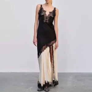 Vue en pied d'une élégante robe longue à bretelles en dentelle noire et satin crème.