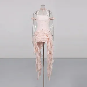 Detailed view of the pink ruffled halter dress with asymmetrical flowing tassels.