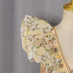 Close-up of yellow floral dress with ruffled lace sleeves and delicate pearl button detail