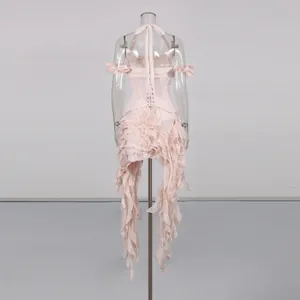 Back view of a pink ruffled halter dress with irregular tassel hem on mannequin