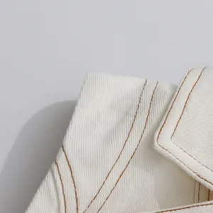 Detailaufnahme von weißem Twill-Stoff mit professionellen braunen Kontrastnähten