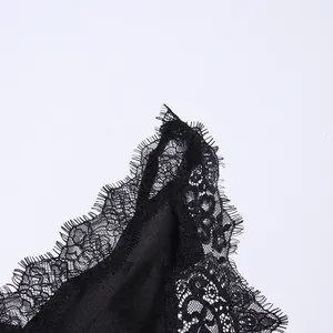 Close-up of delicate black eyelash lace trim on an elegant satin summer slip dress