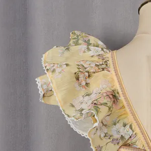 Close-up of elegant ruffle sleeve with white lace trim on yellow floral summer dress
