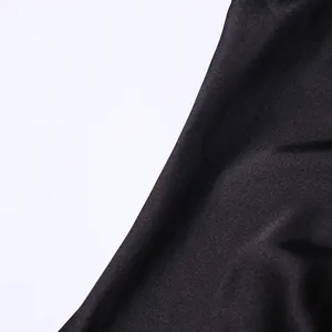 Detailed macro view showing the smooth texture of high-quality black satin dress fabric