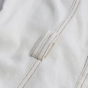 Detailaufnahme der Gürtelschlaufen und Kontrastnähte an einem weißen, lässigen ärmellosen Kleid