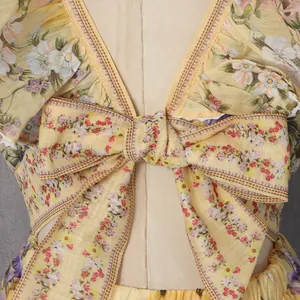 Detailed view of a sweet yellow floral summer dress showing the waist bow and fabric texture