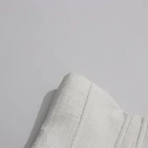 Macro view of the white textured ribbed fabric from a tassel halter neck dress detail