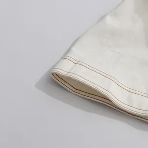 Nahaufnahme des weißen Kleidsaums mit eleganten braunen Kontrastdoppelnaht-Details