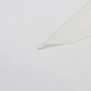 Makro-Detailaufnahme des hochwertigen weißen Stoffträgers eines eleganten Abendkleides.