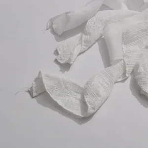 Detailed macro view of the white lace texture on the irregular fringe dress
