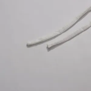 Detailed close-up showing the white fabric straps and soft texture of a designer dress