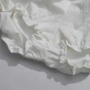 Detailed macro view of white textured fabric with ruffled edges for an ethereal summer dress