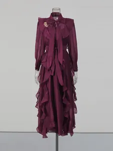 Elegant dark purple long maxi dress with ruffles and bow tie detail shown on mannequin