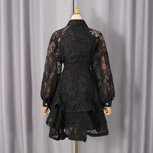 Back view of black lace polka dot dress with elegant floral patterns and ruffled hem.
