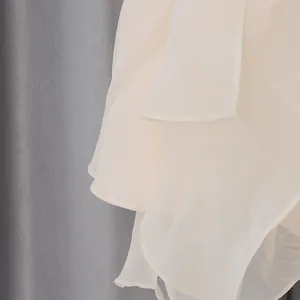 Dettaglio ravvicinato che mostra i morbidi strati a balze di un'elegante gonna lunga in chiffon