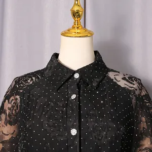 Detail of black lace floral dress with sparkling dots and crystal buttons