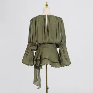 Back view of an elegant green pleated mini dress with puff sleeves on a mannequin.
