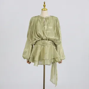Front view of an elegant sage green mini dress with tie neck and tiered ruffled skirt